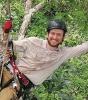 James Ball suspended in a tree doing fieldwork