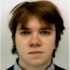 A masculine presenting person with brown hair