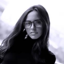 Woman with long dark hair and black rimmed glasses.